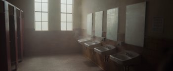 Movie still from “Firestarter” (2022), directed by Keith Thomas – Three sinks in a public bathroom with a window; Extreme Wide shot, High angle