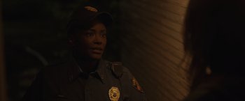 Movie still from “Firestarter” (2022), directed by Keith Thomas – A police officer in uniform is looking at the camera; Close Up shot, Over the shoulder angle