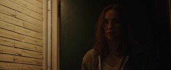 Movie still from “Firestarter” (2022), directed by Keith Thomas – A woman standing next to a window in a room; Close Up shot, Low angle