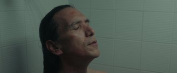 Movie still from “Firestarter” (2022), directed by Keith Thomas – An older man is taking a shower in a bathroom; Close Up shot, High angle