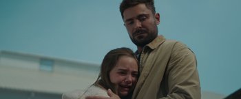 Movie still from “Firestarter” (2022), directed by Keith Thomas – A man and a woman are crying in a room; Close Up shot, Over the shoulder angle