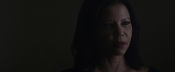 Movie still from “Firestarter” (2022), directed by Keith Thomas – A woman with dark hair is looking at the camera; Close Up shot, Over the shoulder angle