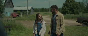 Movie still from “Firestarter” (2022), directed by Keith Thomas – A man and a girl are standing in a field; Medium shot, Over the shoulder angle