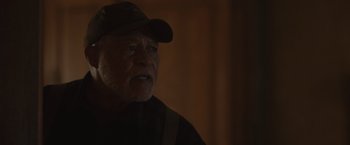 Movie still from “Firestarter” (2022), directed by Keith Thomas – An older man wearing a hat and looking into the distance; Close Up shot, Over the shoulder angle