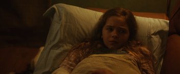 Movie still from “Firestarter” (2022), directed by Keith Thomas – A girl laying in a bed looking sad; Close Up shot, High angle