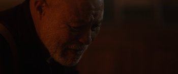 Movie still from “Firestarter” (2022), directed by Keith Thomas – An older man is looking down at his face; Close Up shot, Low angle
