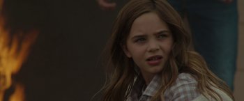 Movie still from “Firestarter” (2022), directed by Keith Thomas – A young girl with long brown hair and a checkered shirt; Close Up shot, Over the shoulder angle