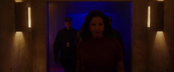 Movie still from “Firestarter” (2022), directed by Keith Thomas – A group of people walking in a dark room; Medium shot, Low angle