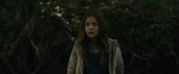 Movie still from “Firestarter” (2022), directed by Keith Thomas – A young girl is standing in the dark; Close Up shot, Over the shoulder angle
