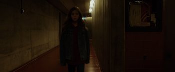 Movie still from “Firestarter” (2022), directed by Keith Thomas – A girl is standing in a dark hallway; Medium shot, Low angle