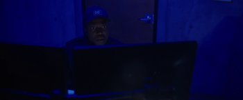 Movie still from “Firestarter” (2022), directed by Keith Thomas – A man sitting in front of a computer monitor; Close Up shot, Low angle