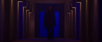 Movie still from “Firestarter” (2022), directed by Keith Thomas – A woman standing in front of a door in a dark room; Wide shot, Low angle