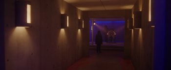 Movie still from “Firestarter” (2022), directed by Keith Thomas – A person standing in a room with a window and lights on; Extreme Wide shot, Low angle
