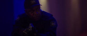 Movie still from “Firestarter” (2022), directed by Keith Thomas – A man in a baseball cap is holding a baseball bat; Close Up shot, Over the shoulder angle