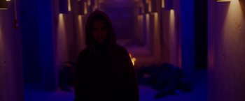 Movie still from “Firestarter” (2022), directed by Keith Thomas – A woman in a hooded jacket standing in a dark room; Wide shot, Over the shoulder angle