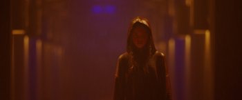 Movie still from “Firestarter” (2022), directed by Keith Thomas – A woman wearing a hooded jacket standing in the dark; Medium shot, Low angle