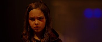 Movie still from “Firestarter” (2022), directed by Keith Thomas – A young girl with a bruised face stares into the camera; Close Up shot, High angle