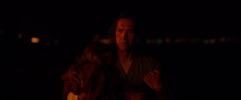 Movie still from “Firestarter” (2022), directed by Keith Thomas – A man and a woman standing next to each other in the dark; Medium shot, Over the shoulder angle