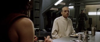 Movie still from “Alien: Resurrection” (1997), directed by Jean-Pierre Jeunet – A man sitting in front of a mirror in front of a cell phone; Medium shot, Over the shoulder angle
