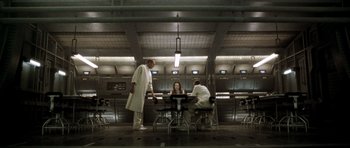 Movie still from “Alien: Resurrection” (1997), directed by Jean-Pierre Jeunet – A group of people sitting at a table in a room; Wide shot, Low angle