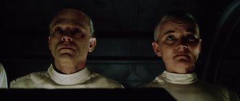 Movie still from “Alien: Resurrection” (1997), directed by Jean-Pierre Jeunet – Two men are standing next to each other; Close Up shot, Low angle