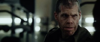 Movie still from “Alien: Resurrection” (1997), directed by Jean-Pierre Jeunet – A person with a beard looking at the camera; Close Up shot, Over the shoulder angle