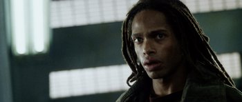 Movie still from “Alien: Resurrection” (1997), directed by Jean-Pierre Jeunet – A person with dreadlocks looking at the camera; Close Up shot, Low angle