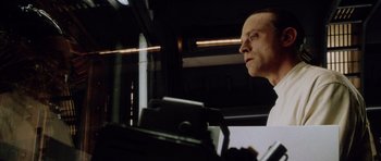 Movie still from “Alien: Resurrection” (1997), directed by Jean-Pierre Jeunet – A man sitting in front of a computer monitor; Close Up shot, Low angle