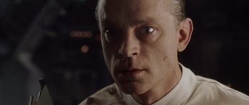 Movie still from “Alien: Resurrection” (1997), directed by Jean-Pierre Jeunet – A person wearing a white shirt; Close Up shot, Low angle