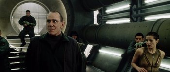 Movie still from “Alien: Resurrection” (1997), directed by Jean-Pierre Jeunet – A man and a woman standing next to each other in a tunnel; Medium shot, Low angle