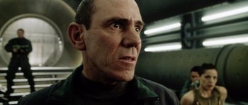 Movie still from “Alien: Resurrection” (1997), directed by Jean-Pierre Jeunet – An older man with a bald head and a goatee looking at the camera; Close Up shot, Low angle