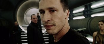 Movie still from “Alien: Resurrection” (1997), directed by Jean-Pierre Jeunet – A man's face in front of another man in the background; Close Up shot, Low angle