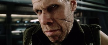 Movie still from “Alien: Resurrection” (1997), directed by Jean-Pierre Jeunet – A person with a scar on his face; Extreme Close Up shot, Low angle