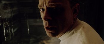 Movie still from “Alien: Resurrection” (1997), directed by Jean-Pierre Jeunet – A man's face in a dimly - lit room; Close Up shot, Low angle