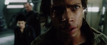 Movie still from “Alien: Resurrection” (1997), directed by Jean-Pierre Jeunet – A man's face in the dark; Close Up shot, Over the shoulder angle