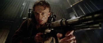 Movie still from “Alien: Resurrection” (1997), directed by Jean-Pierre Jeunet – A person holding a gun in a room; Close Up shot, Low angle