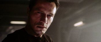 Movie still from “Alien: Resurrection” (1997), directed by Jean-Pierre Jeunet – A person wearing a brown shirt; Close Up shot, Low angle
