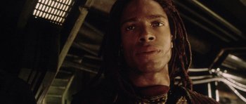 Movie still from “Alien: Resurrection” (1997), directed by Jean-Pierre Jeunet – A person with dreadlocks looking at the camera; Close Up shot, Low angle