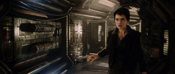 Movie still from “Alien: Resurrection” (1997), directed by Jean-Pierre Jeunet – A woman standing in a dark room; Medium shot, High angle