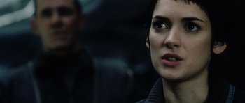 Movie still from “Alien: Resurrection” (1997), directed by Jean-Pierre Jeunet – A woman's face with a man in the background; Close Up shot, Over the shoulder angle