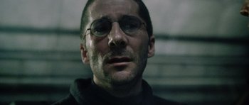 Movie still from “Alien: Resurrection” (1997), directed by Jean-Pierre Jeunet – A person wearing glasses and a sweater; Close Up shot, Low angle