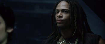 Movie still from “Alien: Resurrection” (1997), directed by Jean-Pierre Jeunet – A person with dreads looking at the camera; Close Up shot, Low angle