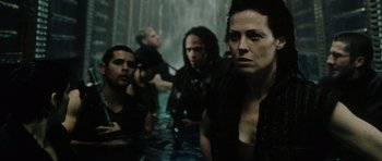 Movie still from “Alien: Resurrection” (1997), directed by Jean-Pierre Jeunet – A group of people sitting in a pool of water; Medium shot, Over the shoulder angle