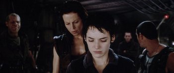 Movie still from “Alien: Resurrection” (1997), directed by Jean-Pierre Jeunet – A woman standing next to another woman in a dark room; Close Up shot, Low angle