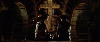 Movie still from “Alien: Resurrection” (1997), directed by Jean-Pierre Jeunet – A group of people standing in front of a large cross; Wide shot, Overhead angle