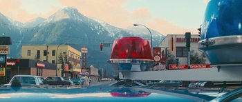 Movie still from “First Blood” (1982), directed by Ted Kotcheff – A traffic light sitting on the side of a road; Extreme Wide shot, Low angle