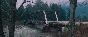 Movie still from “First Blood” (1982), directed by Ted Kotcheff – An old wooden bridge crossing a river in a wooded area; Extreme Wide shot, High angle
