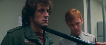 Movie still from “First Blood” (1982), directed by Ted Kotcheff – A man holding a baseball bat over another man's head; Close Up shot, Over the shoulder angle