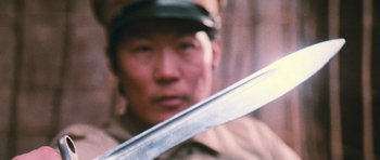 Movie still from “First Blood” (1982), directed by Ted Kotcheff – A man holding a sword in front of his face; Extreme Close Up shot, Low angle