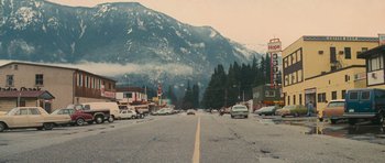 Movie still from “First Blood” (1982), directed by Ted Kotcheff – Cars are driving down the street in the middle of the road; Extreme Wide shot, High angle